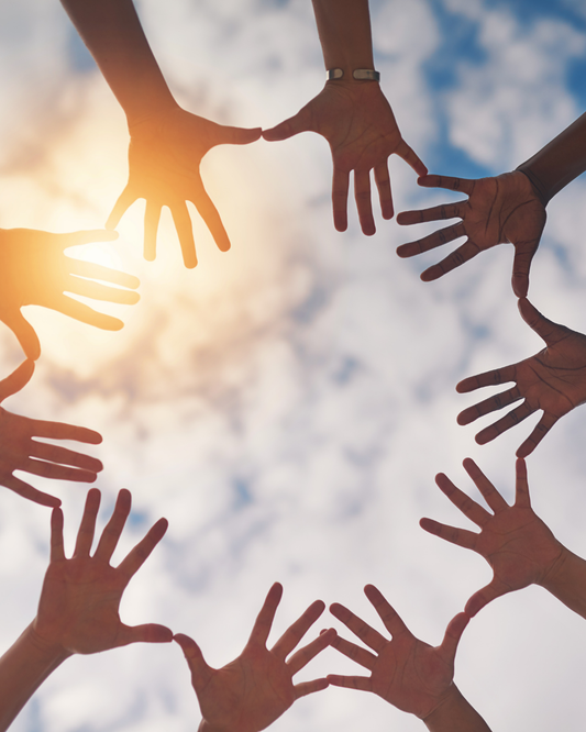 a photograph of many pairs of hands in a circle